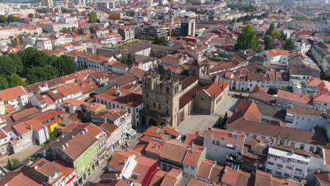 drone orbiting over the beautiful city of braga with red roof buildings and braga cathedral on a sunny summer day in portugal