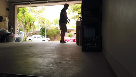 hombre saliendo de la casa a través del garaje, buscando algo