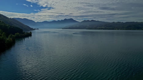 Vista-Aérea-Del-Lago-Attersee-En-Austria-Con-Montañas-Distantes-Y-Cielos-Despejados