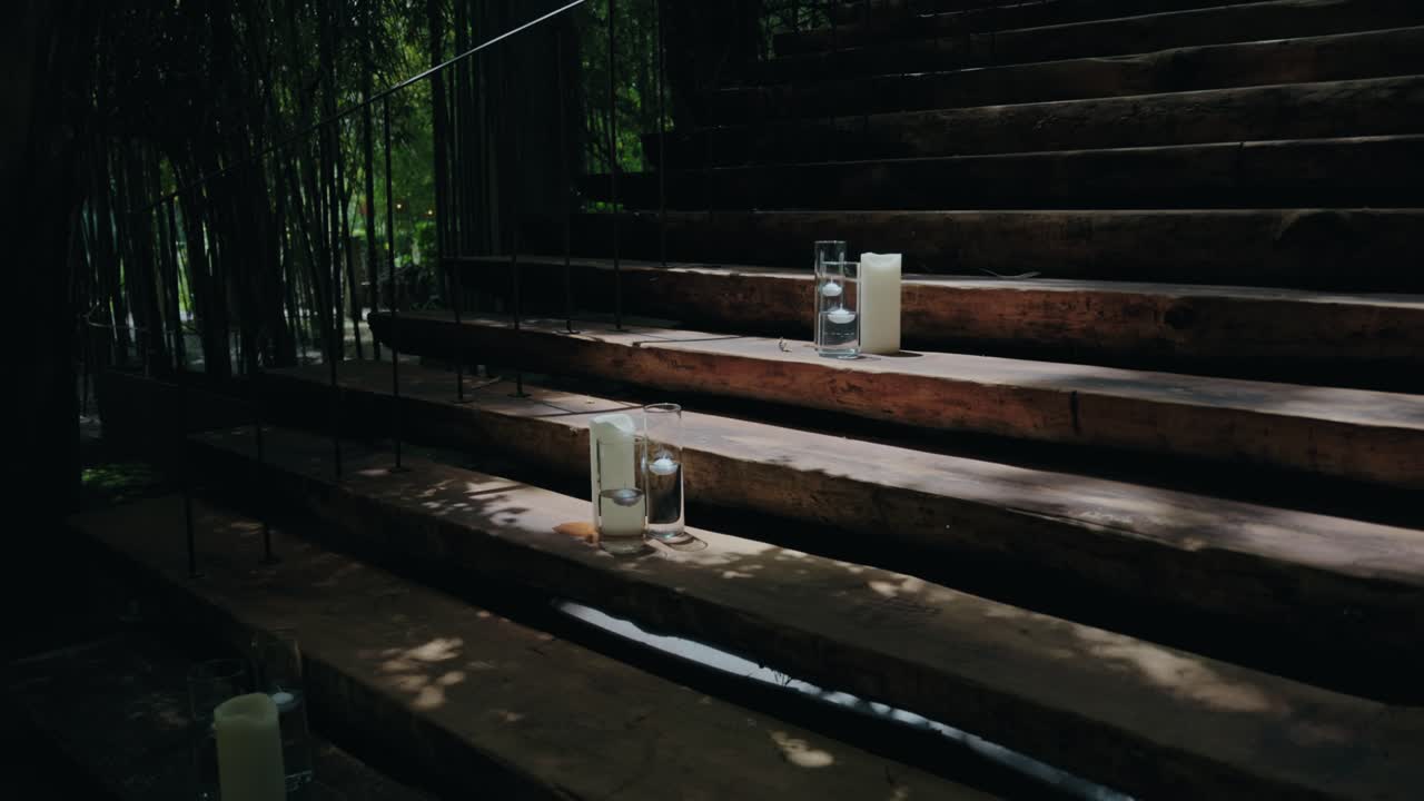 candles on wooden steps in quiet forest with dappled natural light