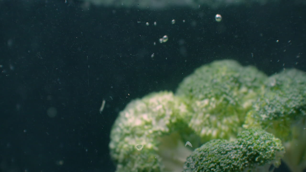 Green fresh broccoli washed in clear water before cooking slow motion