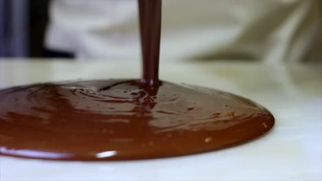 drope chocolate on the natual stone surface for tempering of the chocolate production of chocolates