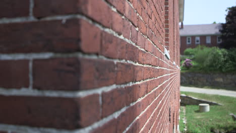 the camera moves along a brick wall of a house or home