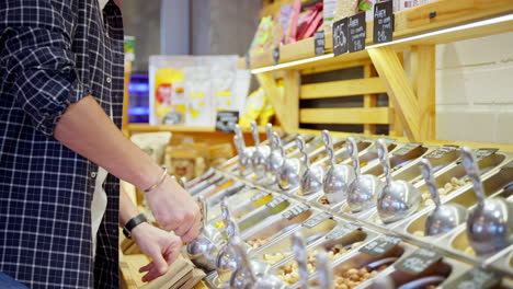 customer purchasing nuts from a bulk food store