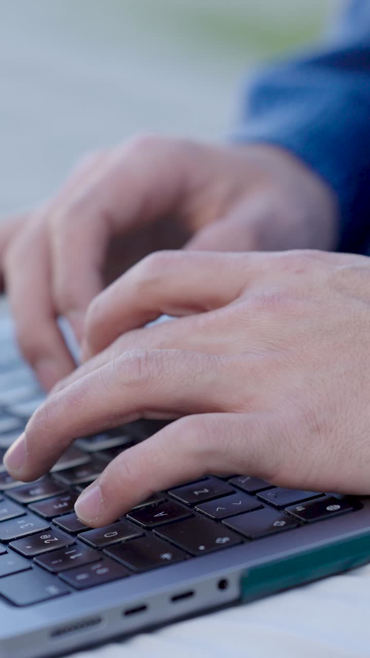 Programmer writing code on laptop keyboard. Vertical
