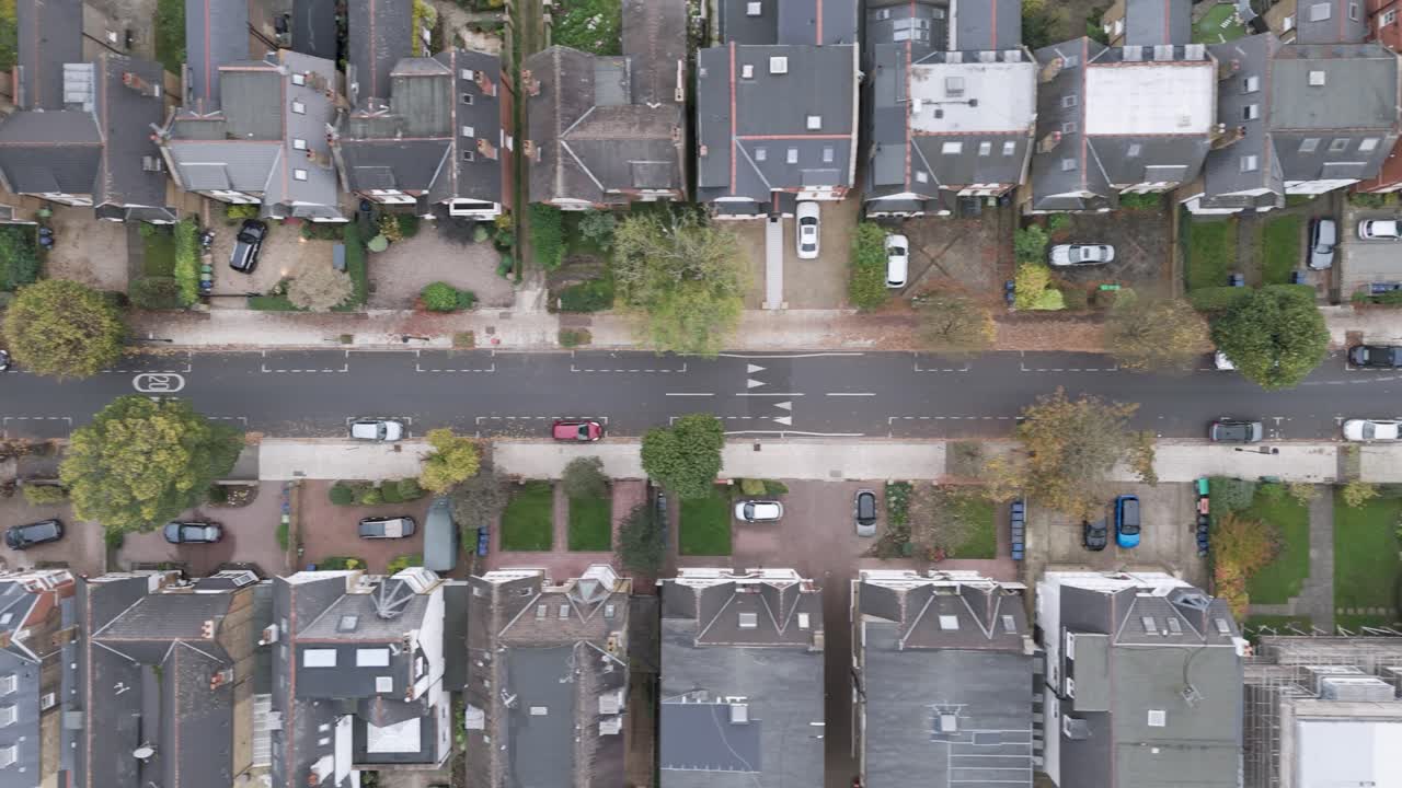 Direct overhead view of residential row houses with autumn foliage and parallel street patterns showcasing urban housing layout in Ealing, London, UK