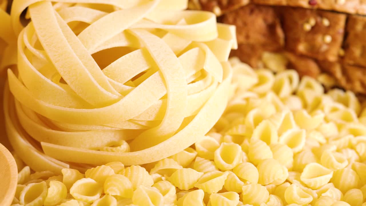 Close-up shots of various grains, pasta, and bread under warm lighting, highlighting textures and colors