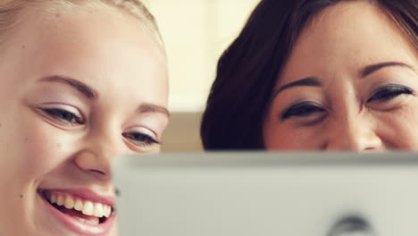 dos mujeres jóvenes usando una tableta con pantalla táctil ipad