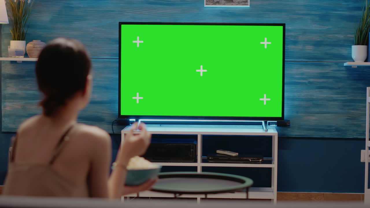 Woman looking at tv designed with green screen