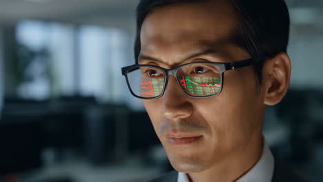 man analyzing stock market data reflected in glasses