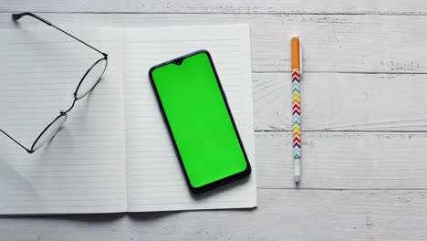 top view of smart phone and notepad on table