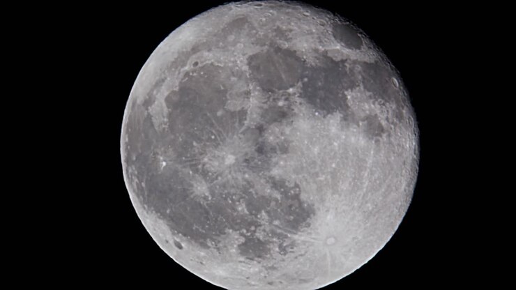 Lua cheia detalhada contra o céu noturno escuro e preto
