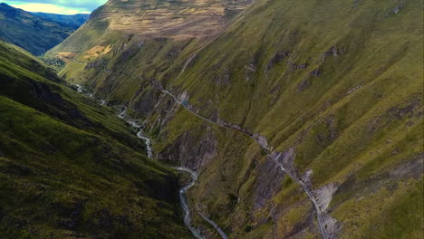 an aerial shot of a train going around the "nariz del diablo" or devil's nose in alausí, chimborazo province, ecuador