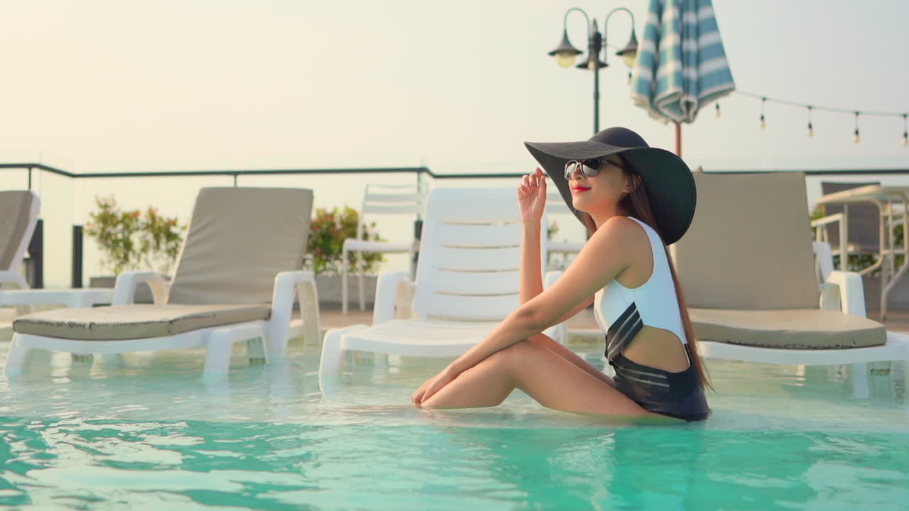 Woman in swimsuit and hat relaxing in a pool