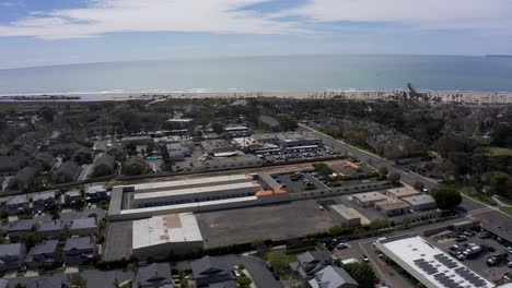 Aerial-high-panning-shot-of-an-industrial-complex-in-Port-Hueneme,-California-with-the-Channel-Islands-visible-in-the-background