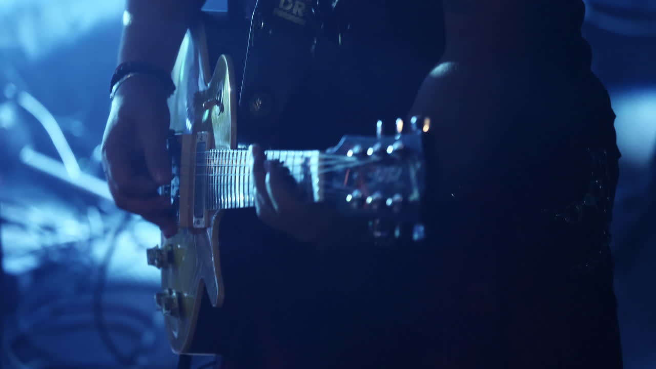 Un uomo si diverte a suonare una chitarra elettrica a un concerto vivace - Primo piano.