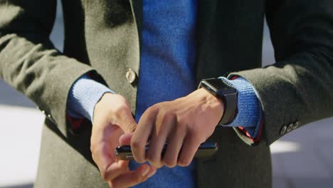 man using mobile phone and smartwatch on street 4k