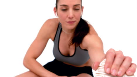 Smiling-female-athlete-stretching-her-leg