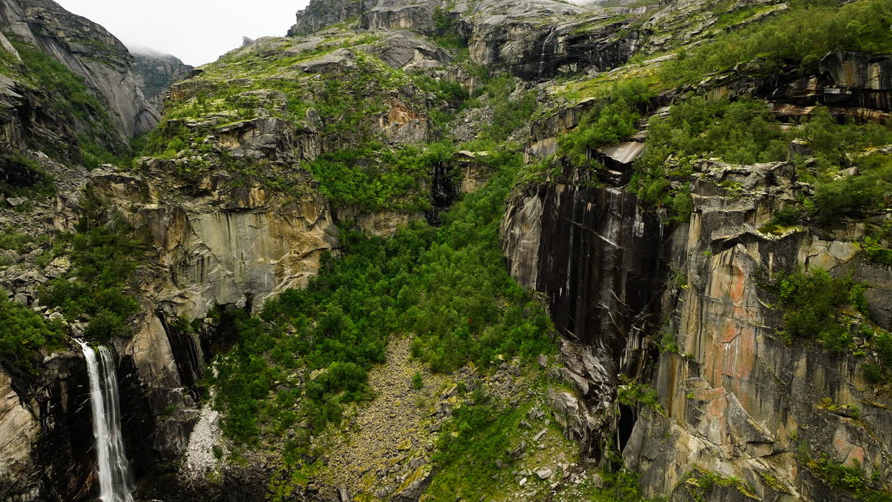 vista aérea panorámica de las cataratas sobre el acantilado en el cañón alpino de hellmojuvet, noruega