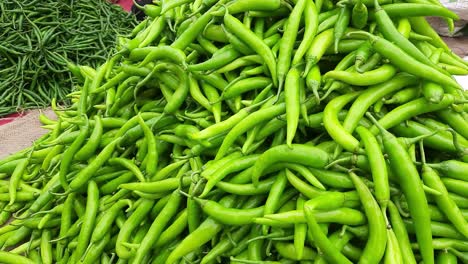 close-up top view of freshly harvested green chilies, and capsicum, displayed in the weekly market for sale in maharashtra india