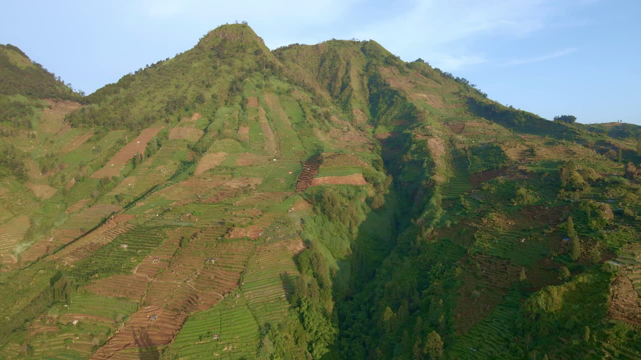 montaña masiva con campos agrícolas en el lado, vista aérea de avión no tripulado