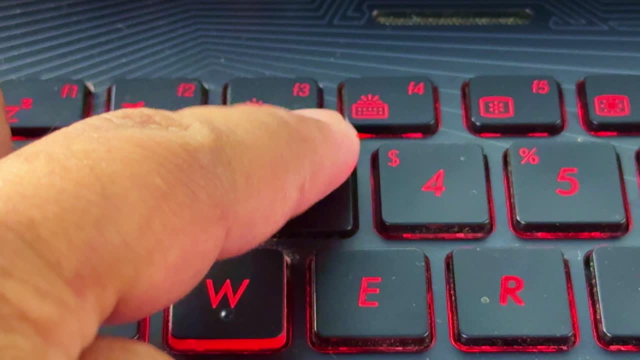 Finger typing on laptop keyboard in "3" button, glowing red keys highlighting technology theme