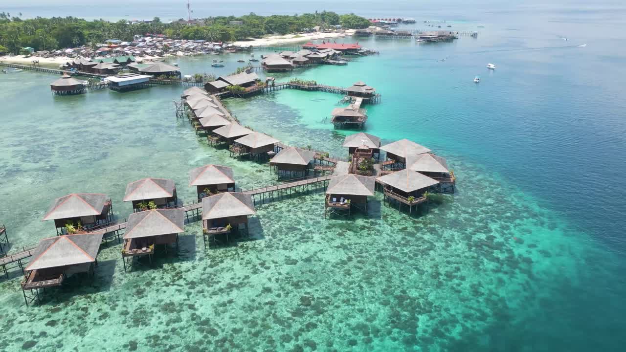 tomada en órbita de bungalows en el pueblo de agua cristalina de sipadan, sabah, malasia