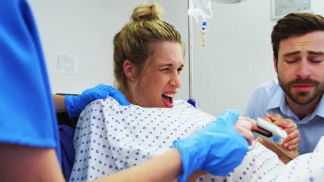 man holding hand of pregnant woman in operating room