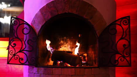 wooden logs burning in fireplace. beautiful brick fireplace with modern design. cosiness and comfort at home in winter.