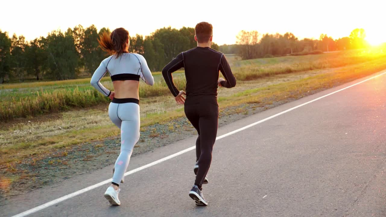 Couple Running on Road at Sunset