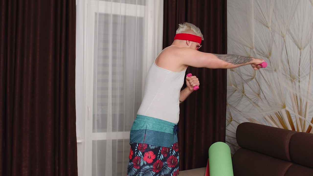 웃긴 남자 운동선수 수염을 가진 스포츠맨은 운동을 합니다. 스트레칭 운동, 집에서 스포츠를 연습합니다.