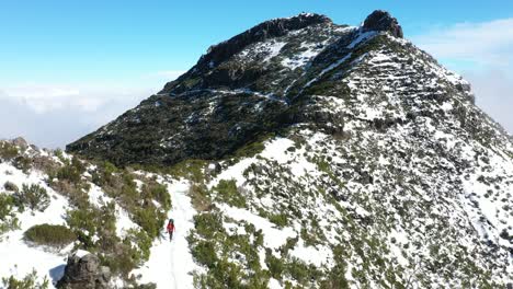 A-woman-in-a-red-jacket-is-walking-alone-on-the-mountain-Pico-Ruivo-in-Madeira