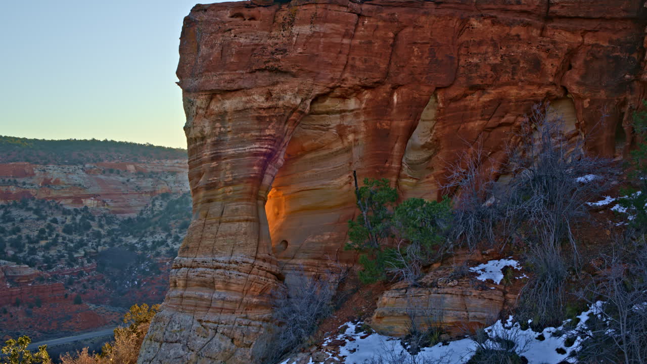 Cinematic drone shot showcasing a secret rock arch illuminated by the first light of day near Kanab, Utah.