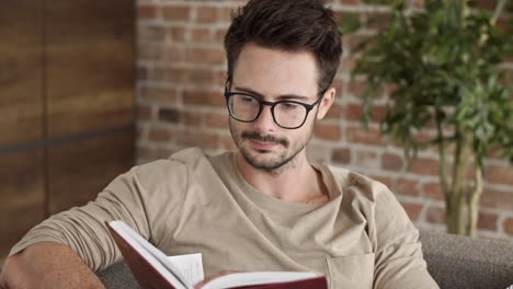 man reading a book at home office