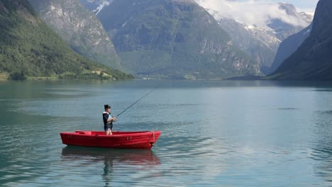 la mujer en el barco atrapa un pez en el giro en noruega.
