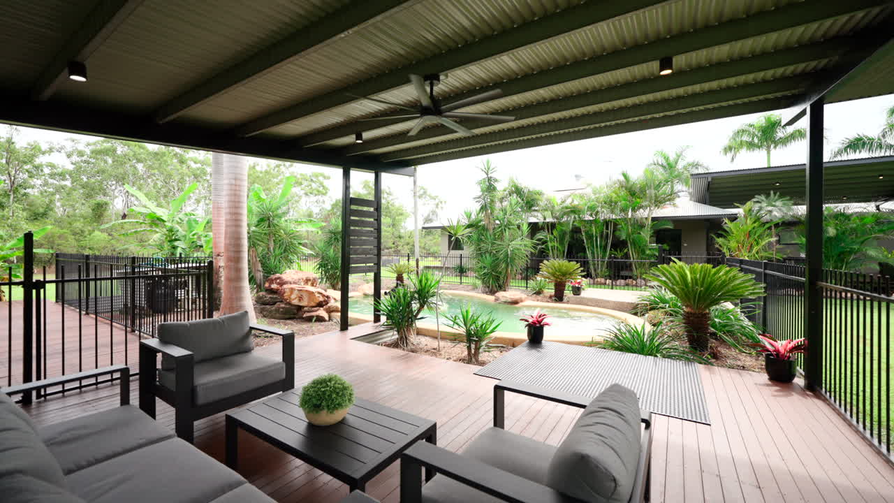 Large Tropical Pool With Patio Sitting Area and Shade Area over Drainage in Backyard. Exterior of house home for real estate property.