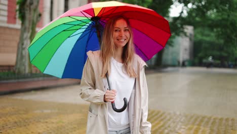 Frau-Mit-Einem-Bunten-Regenschirm,-Die-Im-Regen-Läuft