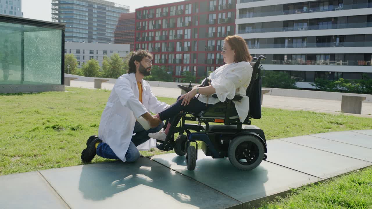 Doctor assisting a patient in a wheelchair outdoors