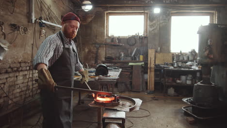 blacksmith shaping wrought iron rod in workshop