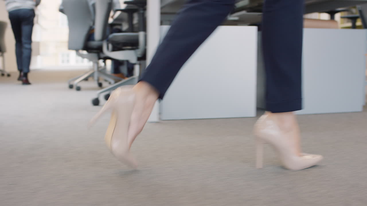 Closeup of Business power woman leader's feet walking through busy  corporate office planning her next success strategy