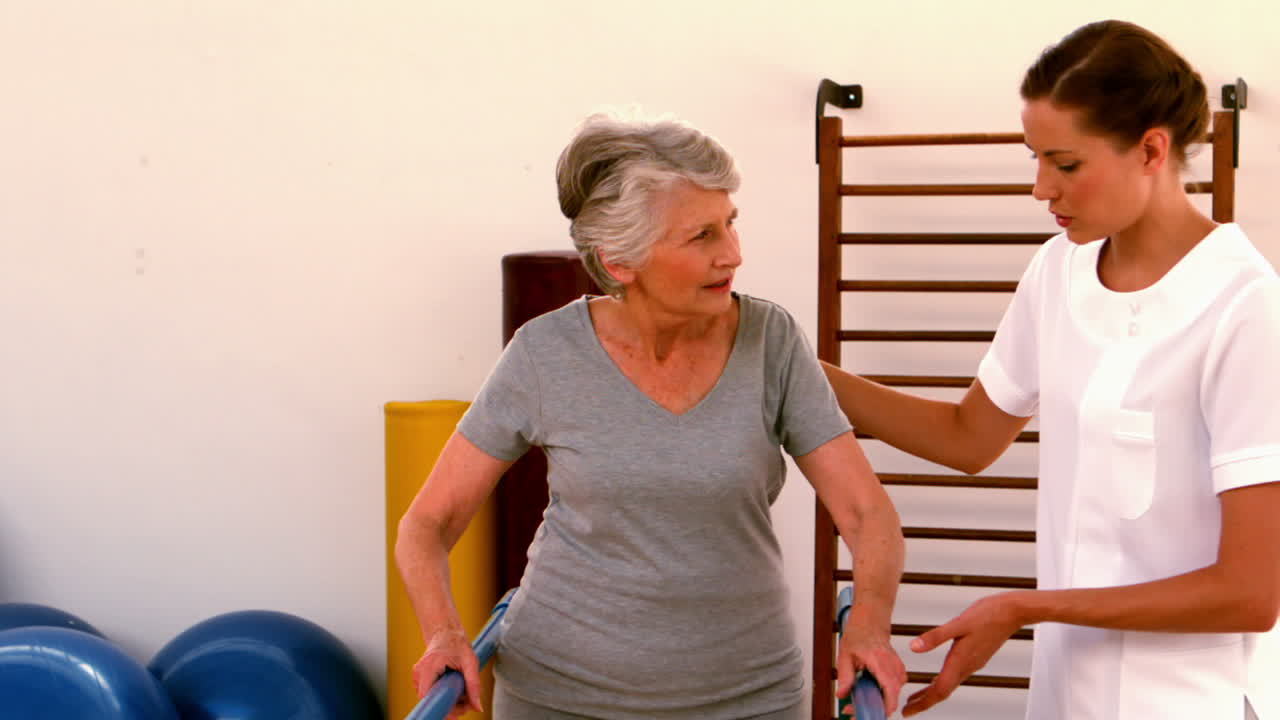 병행 바 를 사용 하여 환자 가 걸을 수 있도록 돕는 물리 치료사