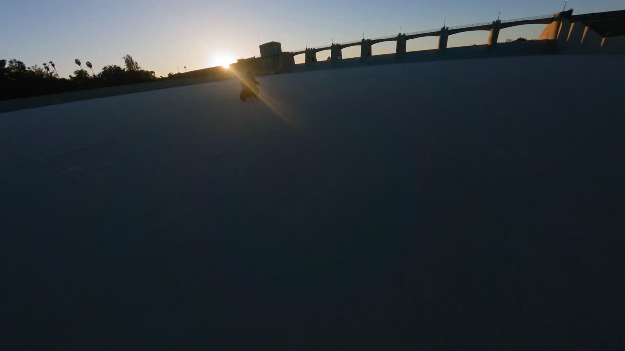 fpv 무인 항공기에 빠르게 타고 자전거 타는 사람 실루엣을 따르십시오