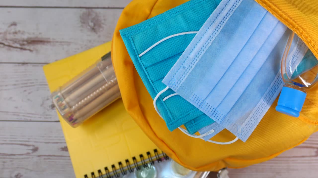 학교 용품과 얼굴 마스크와 손 소독제를 가지고 학교로 돌아갑니다.