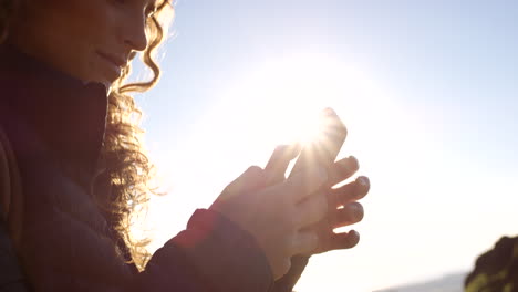 mujer usando un teléfono inteligente al aire libre a la luz del sol