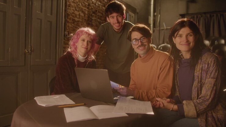 Group Portrait of Actors and Director with Laptop and Papers on Theater Stage