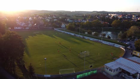 Luftaufnahme-Des-Grünen-Fußballplatzes-Mit-Aktiven-Spielern,-Die-üben