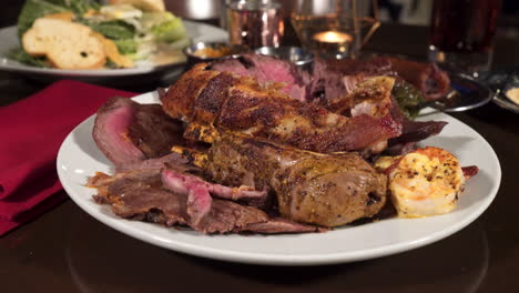 tongs remove meat from overloaded plate of various cuts of beef, pork and shrimp, push slide 4k