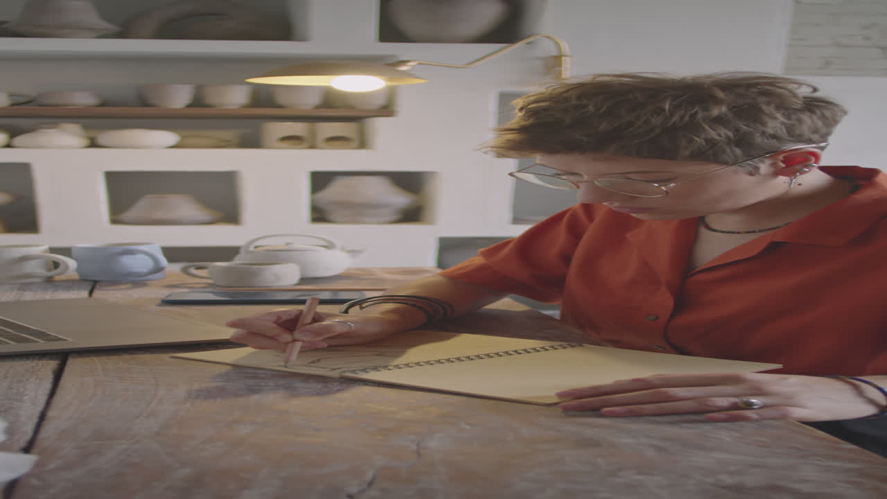 Female Designer Drawing Sketch in Ceramics Workshop