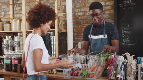 customer paying for shopping at checkout of sustainable plastic free grocery store