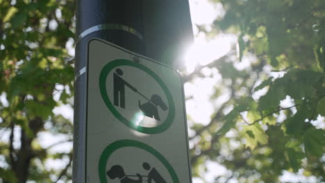 Close-up-of-a-sign-indicating-owners-must-leash-their-dogs